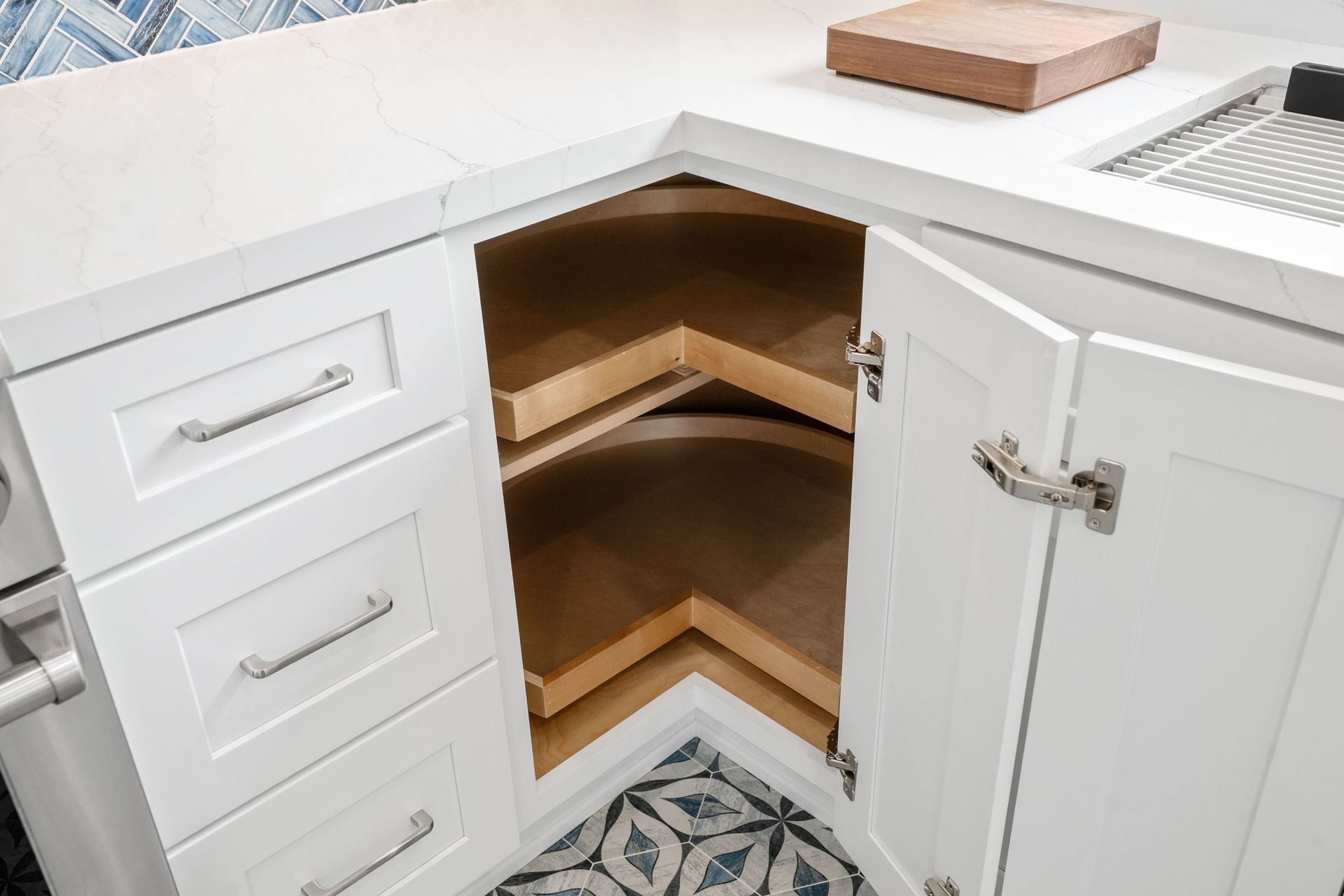 White kitchen corner cabinet with pull-out shelves and a white countertop