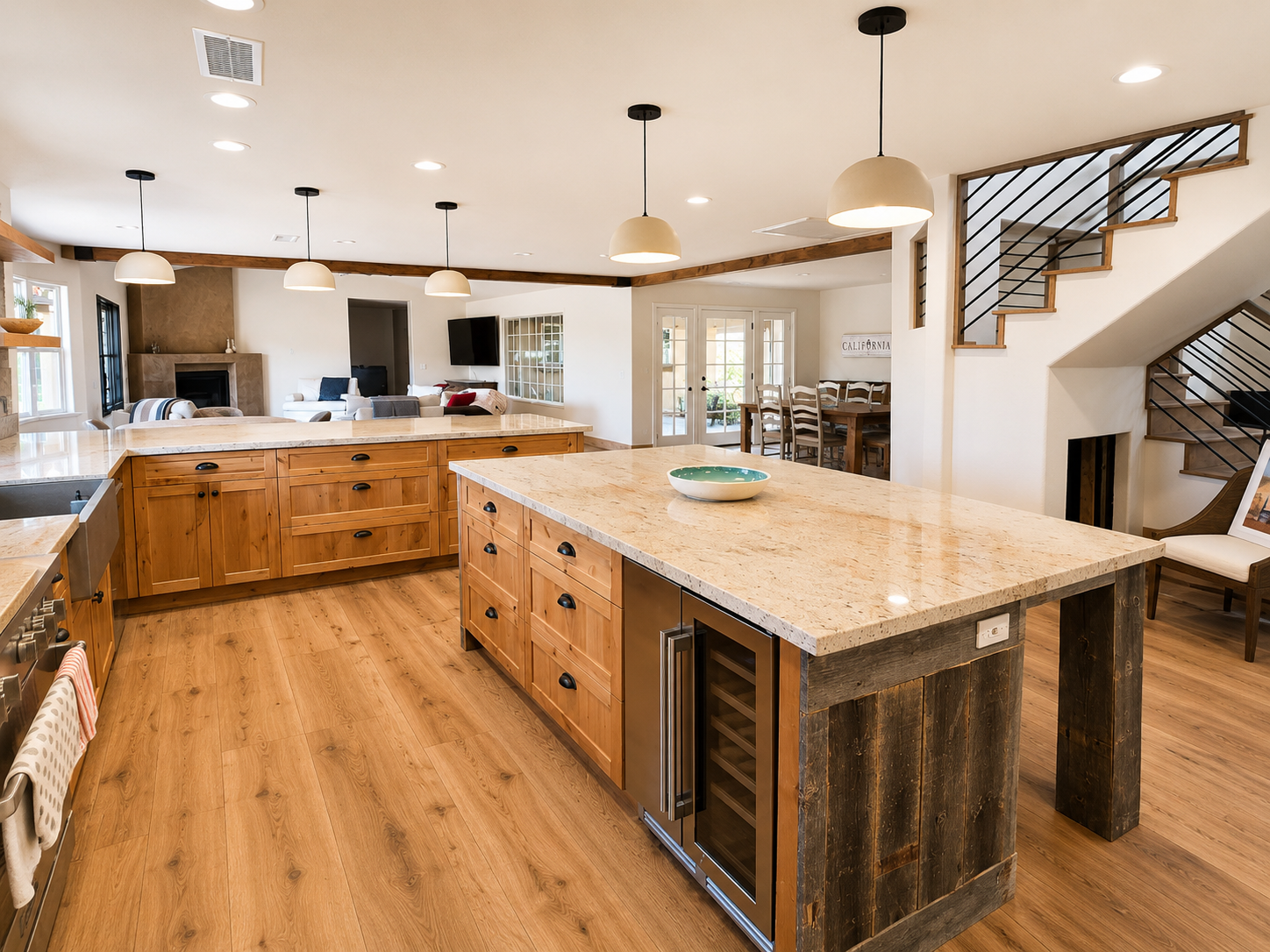 Modern kitchen with white cabinets, large island, pendant lights, and dining table by bright windows