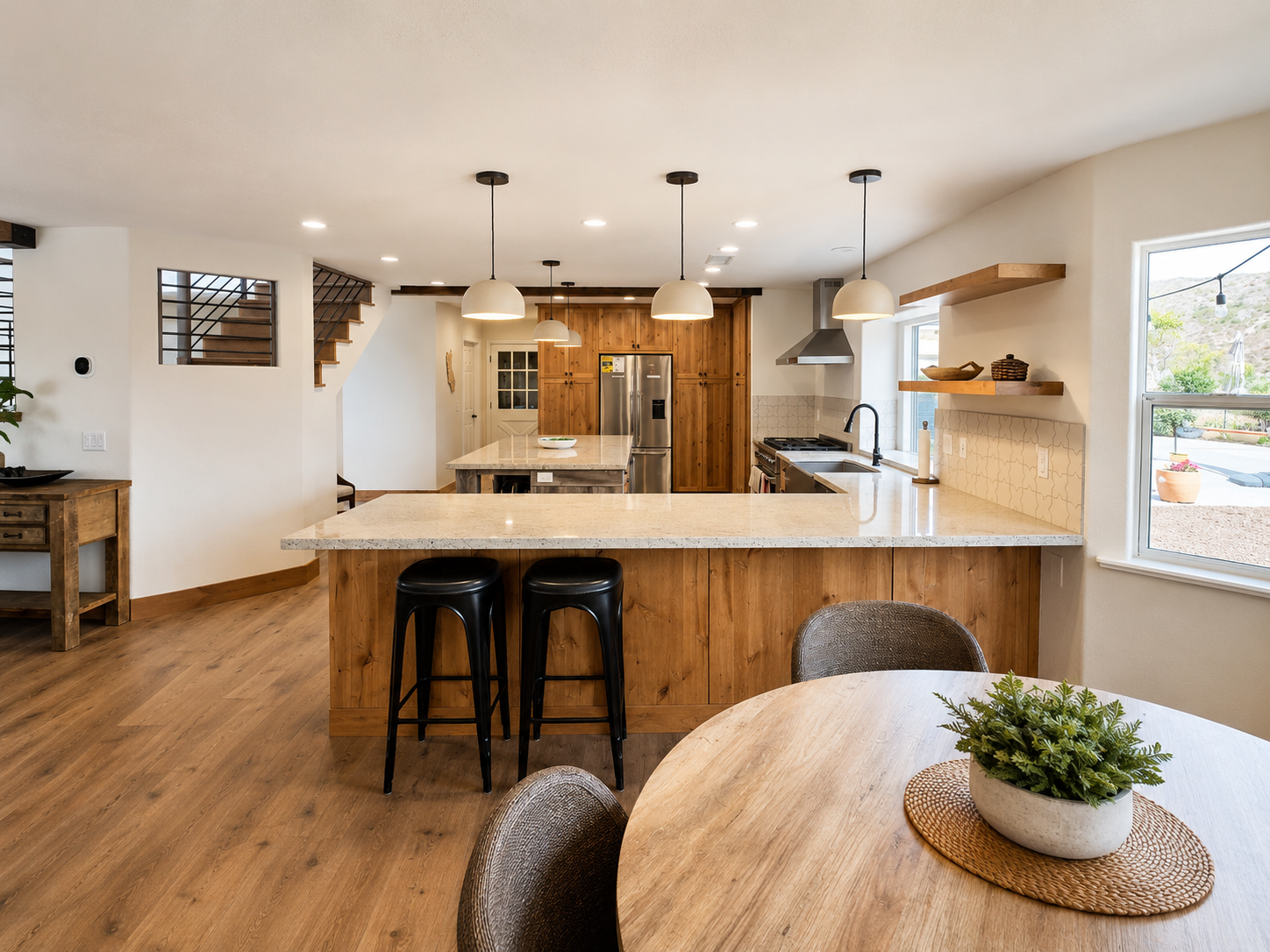 Modern kitchen with navy and white cabinets, marble counters, gold faucet, and stainless steel stove