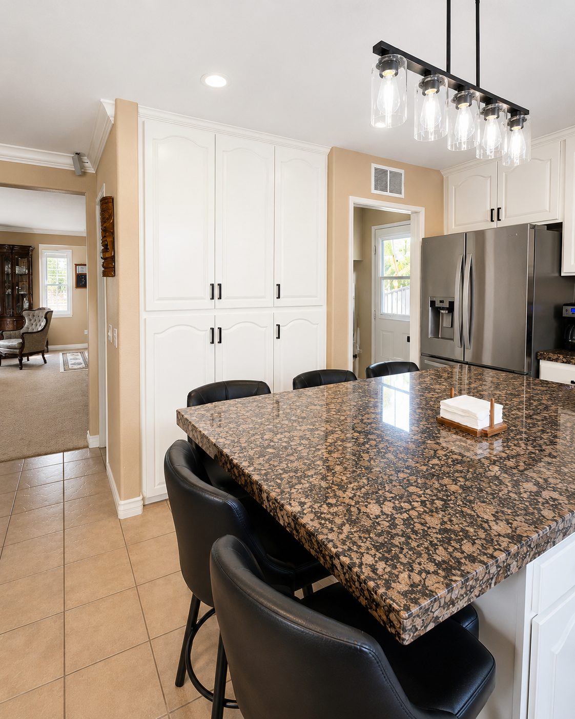 Bright white modern kitchen with stainless steel appliances and marble island countertop