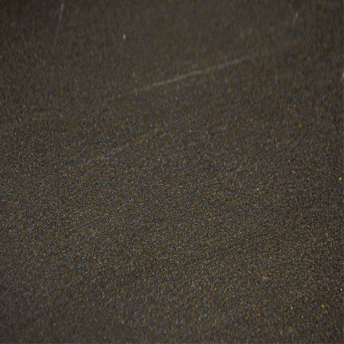 A close up of a black surface with a grainy texture