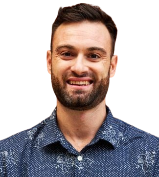 A man with a beard is smiling and wearing a blue shirt