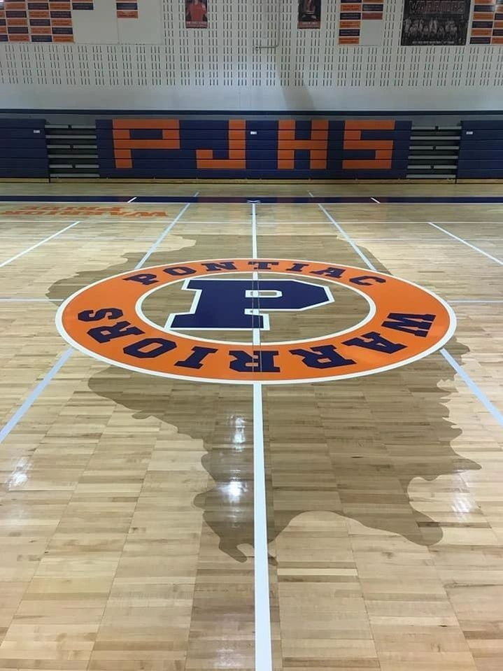 A basketball court with an orange and blue logo of