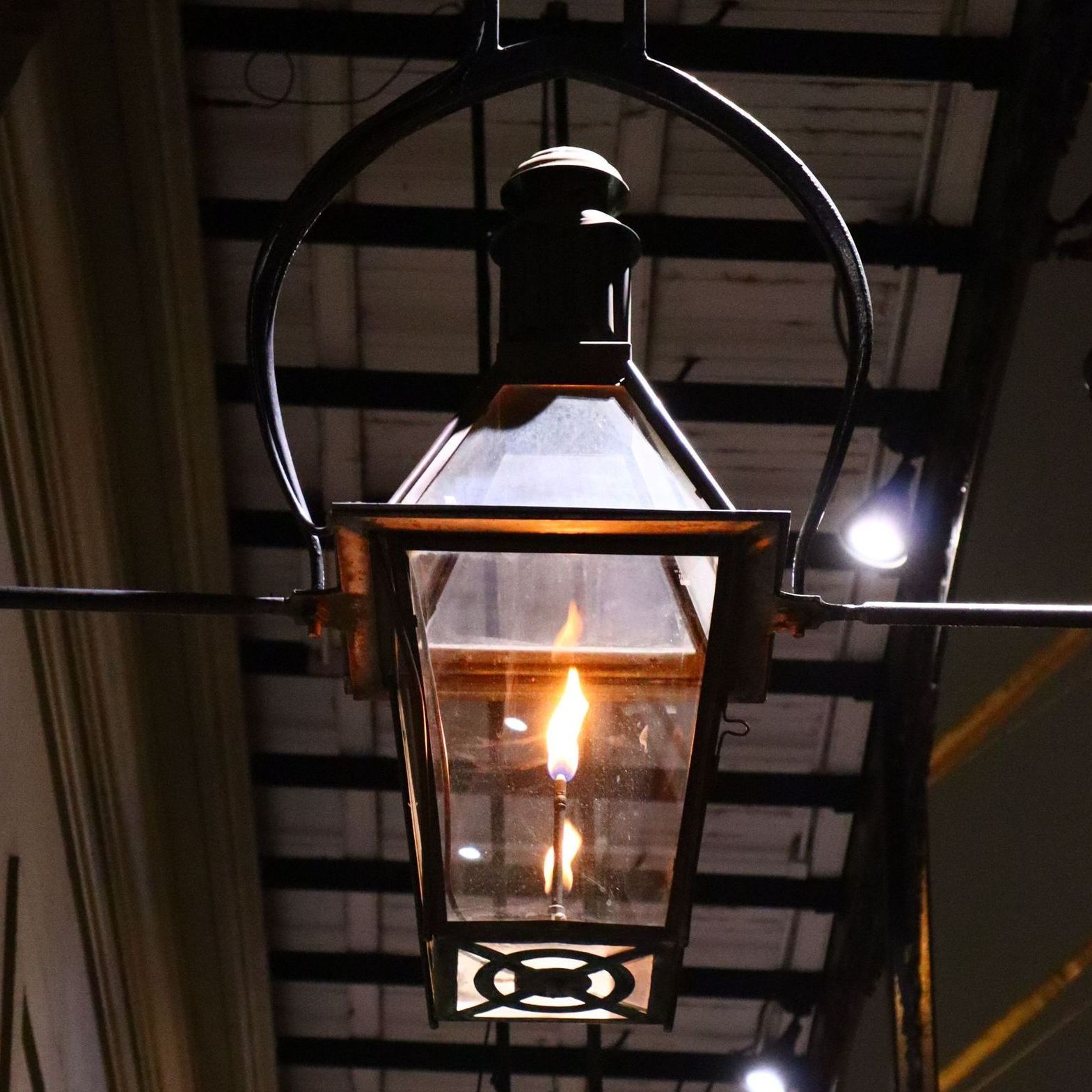 A lantern hanging from the ceiling with a light inside