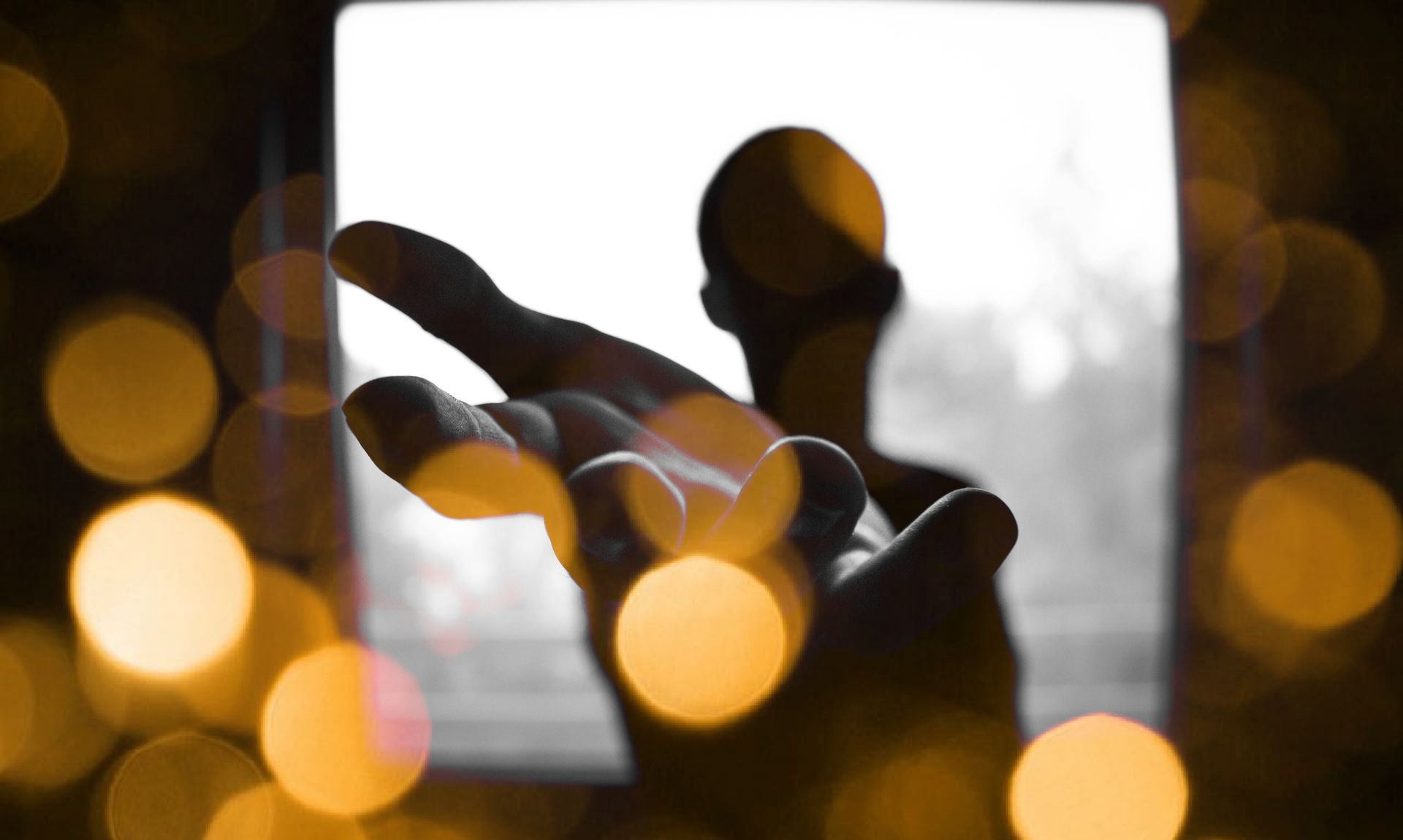 A person is holding a microphone in their hand in front of a window.