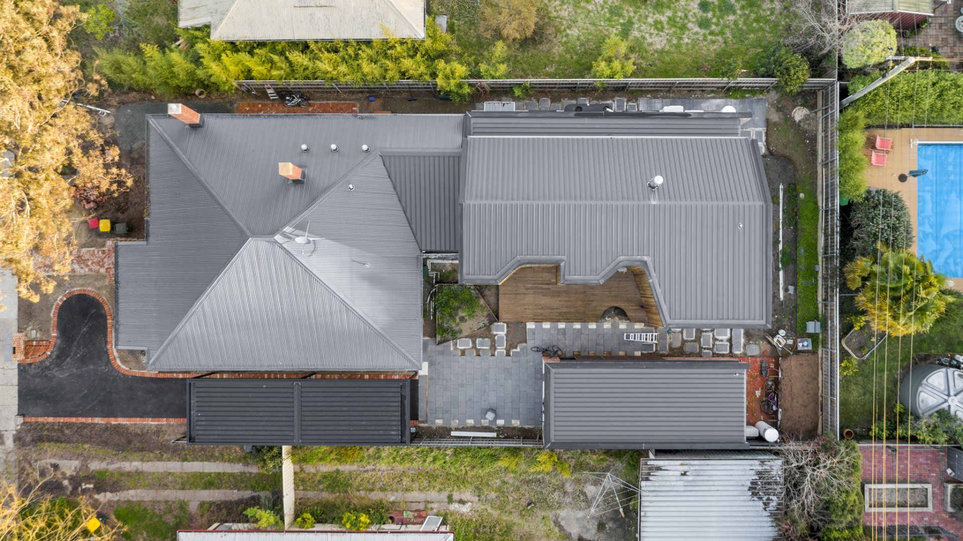 Overhead view of a house with a gray roof and a pool in the backyard.