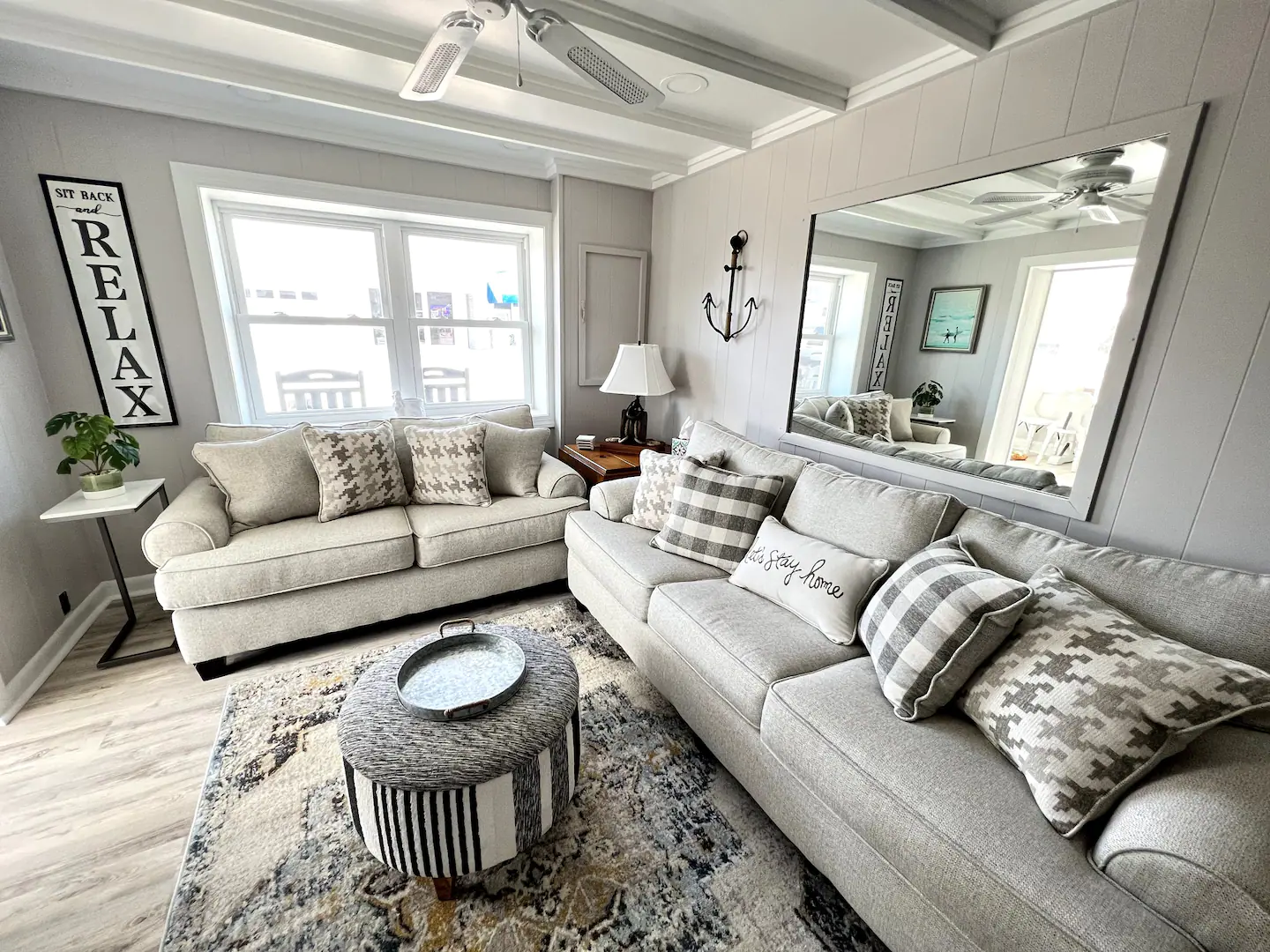 A living room filled with furniture and a large mirror.