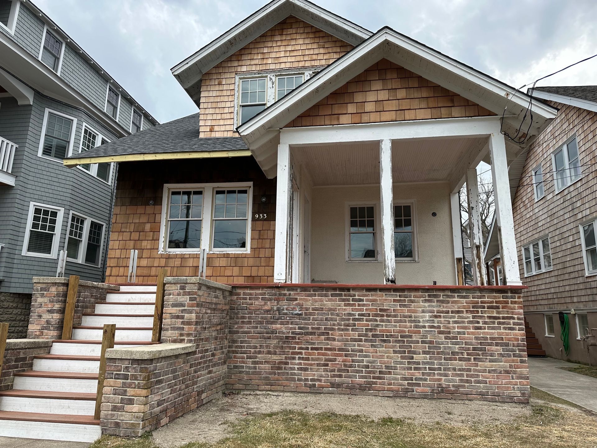 A house with a porch and stairs is being remodeled.