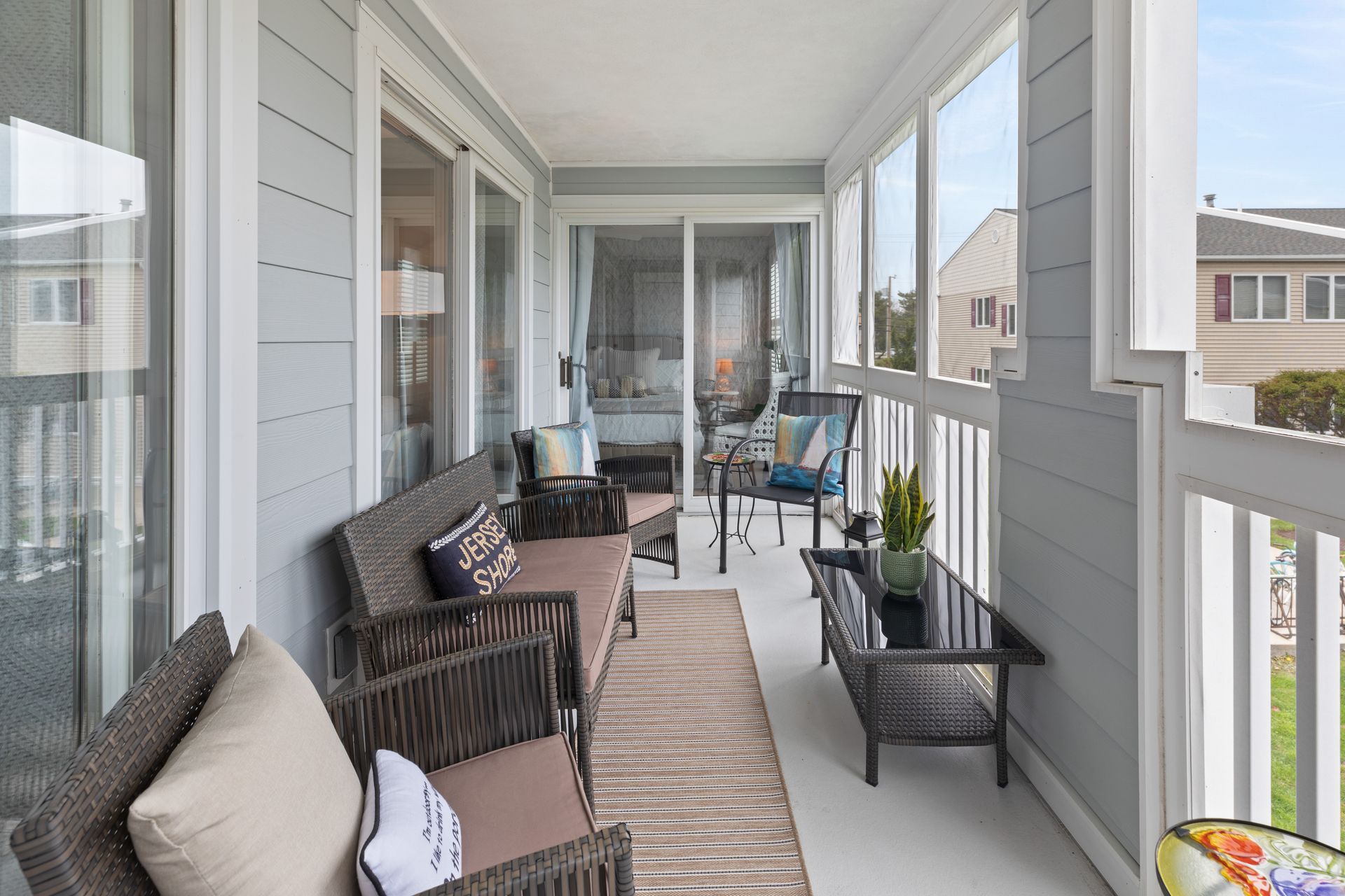 A porch with a couch , chairs , and a coffee table.