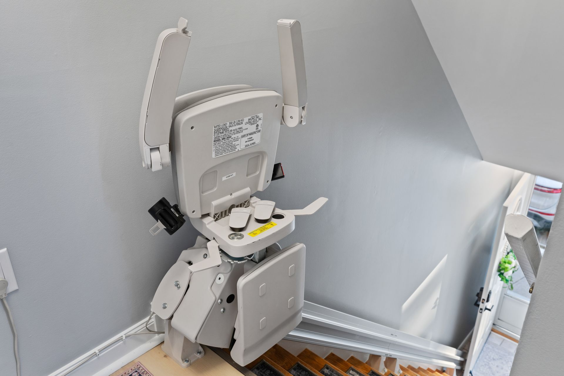 A white stair lift is sitting on top of a set of stairs.