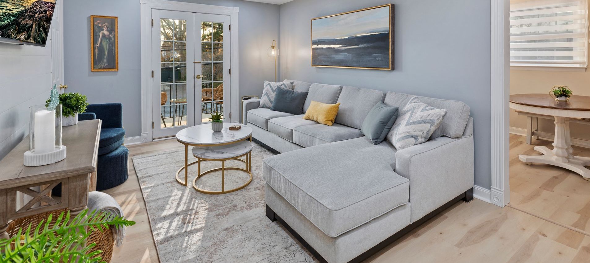 A living room with a couch , table , chairs and sliding glass doors.