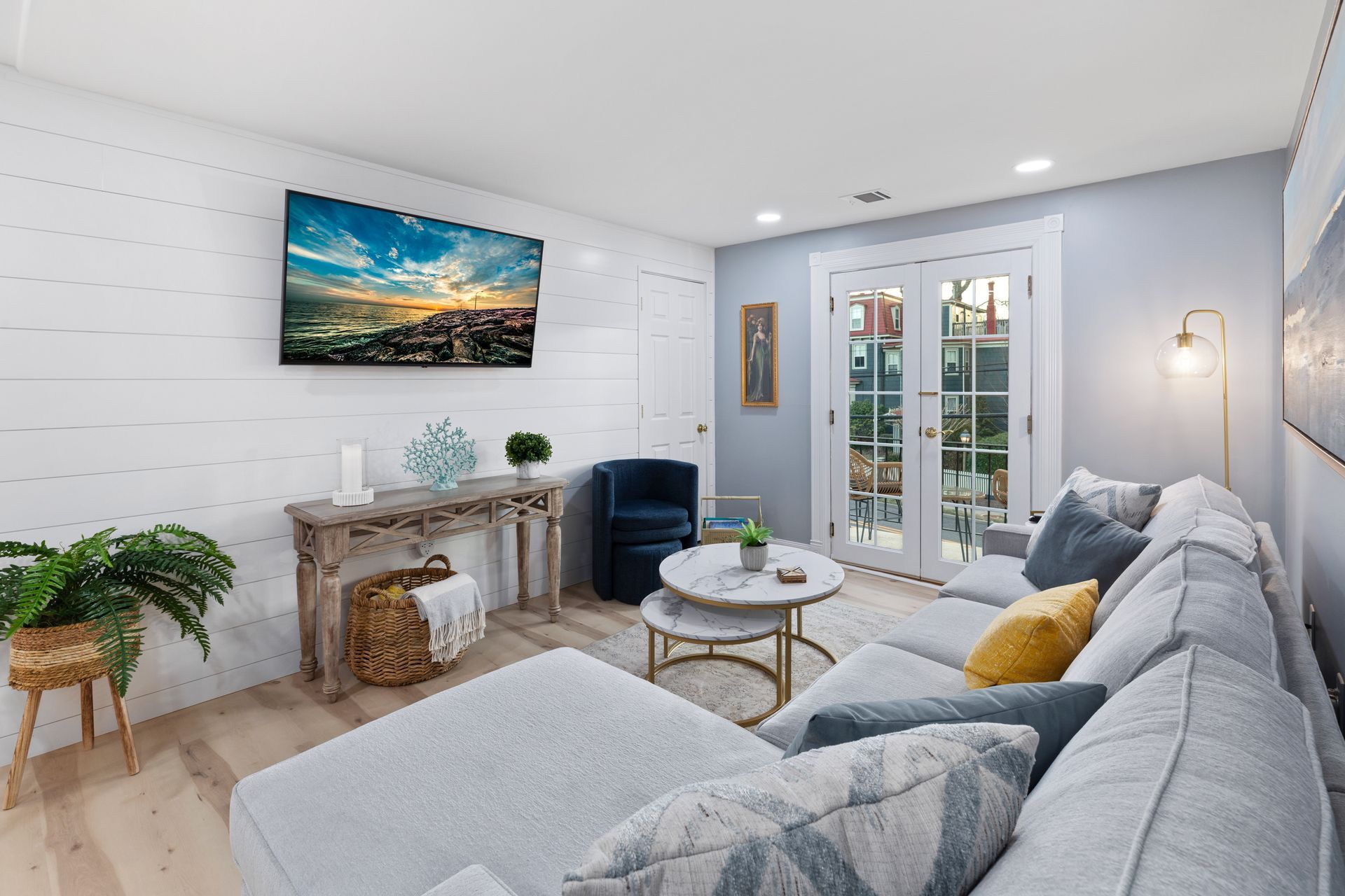 A living room with a couch , chair , table and television.