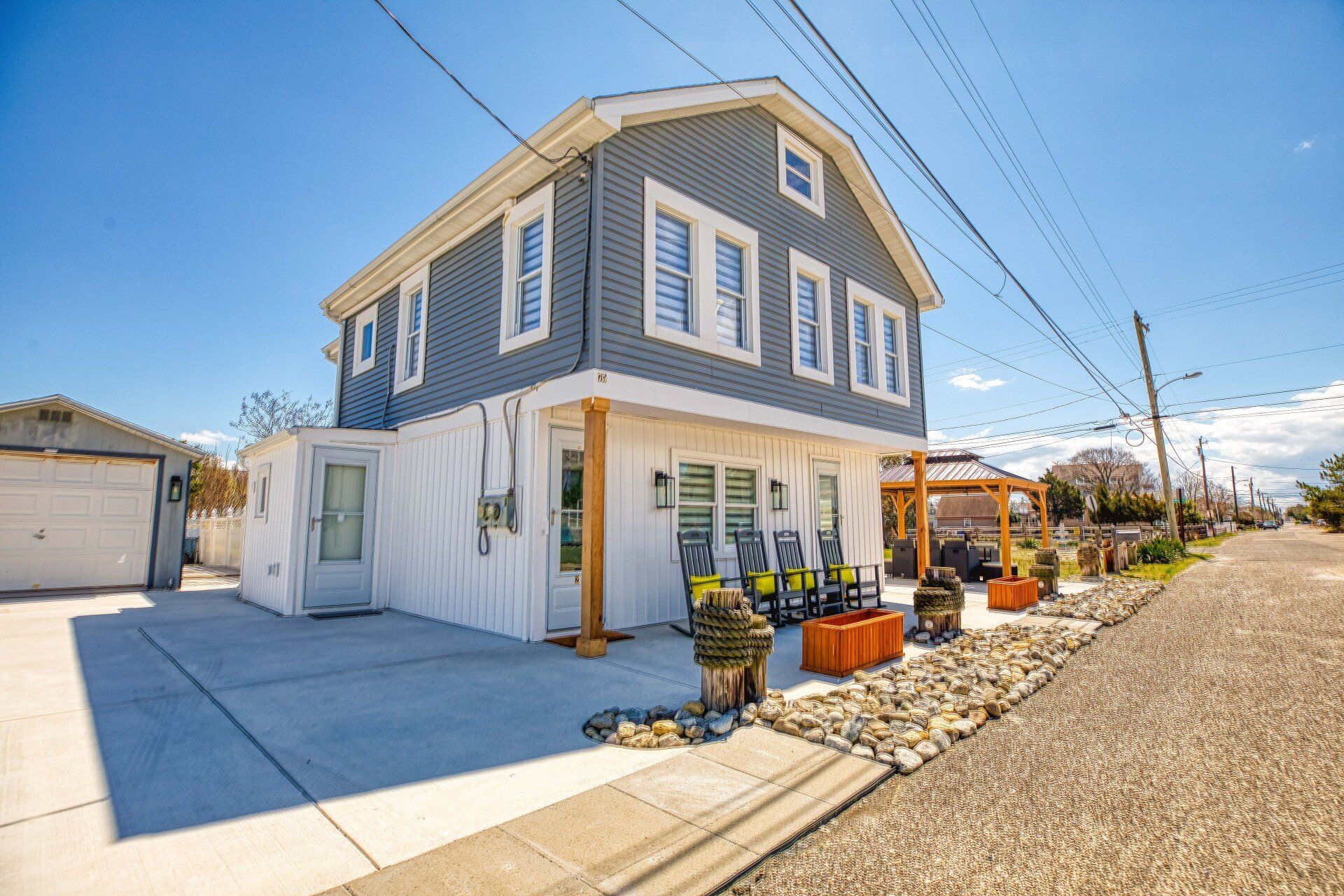Cape May  Bayside Love rental A large gray and white house is sitting on the side of a road.