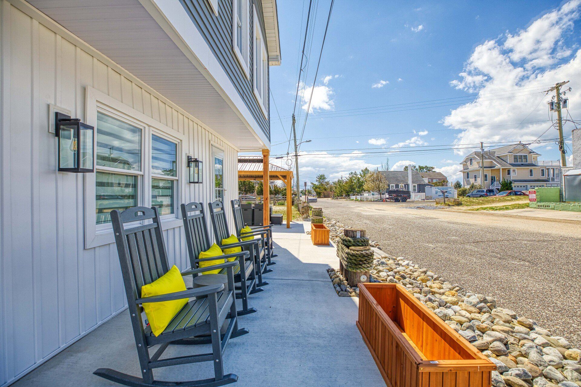 A row of rocking chairs on the porch of a house.