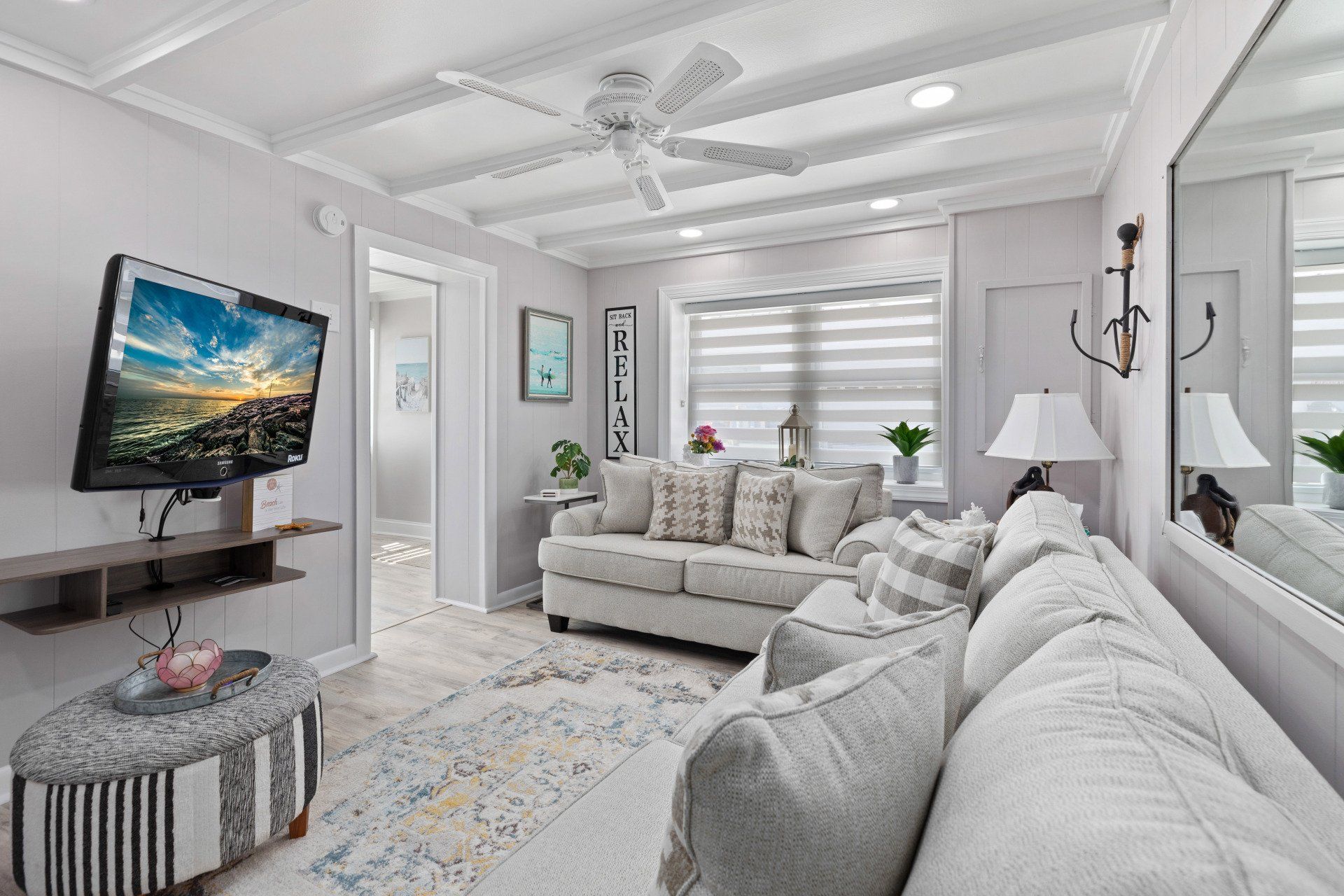 Cape May  Bayside Love rental  living room with a couch , television and ceiling fan.
