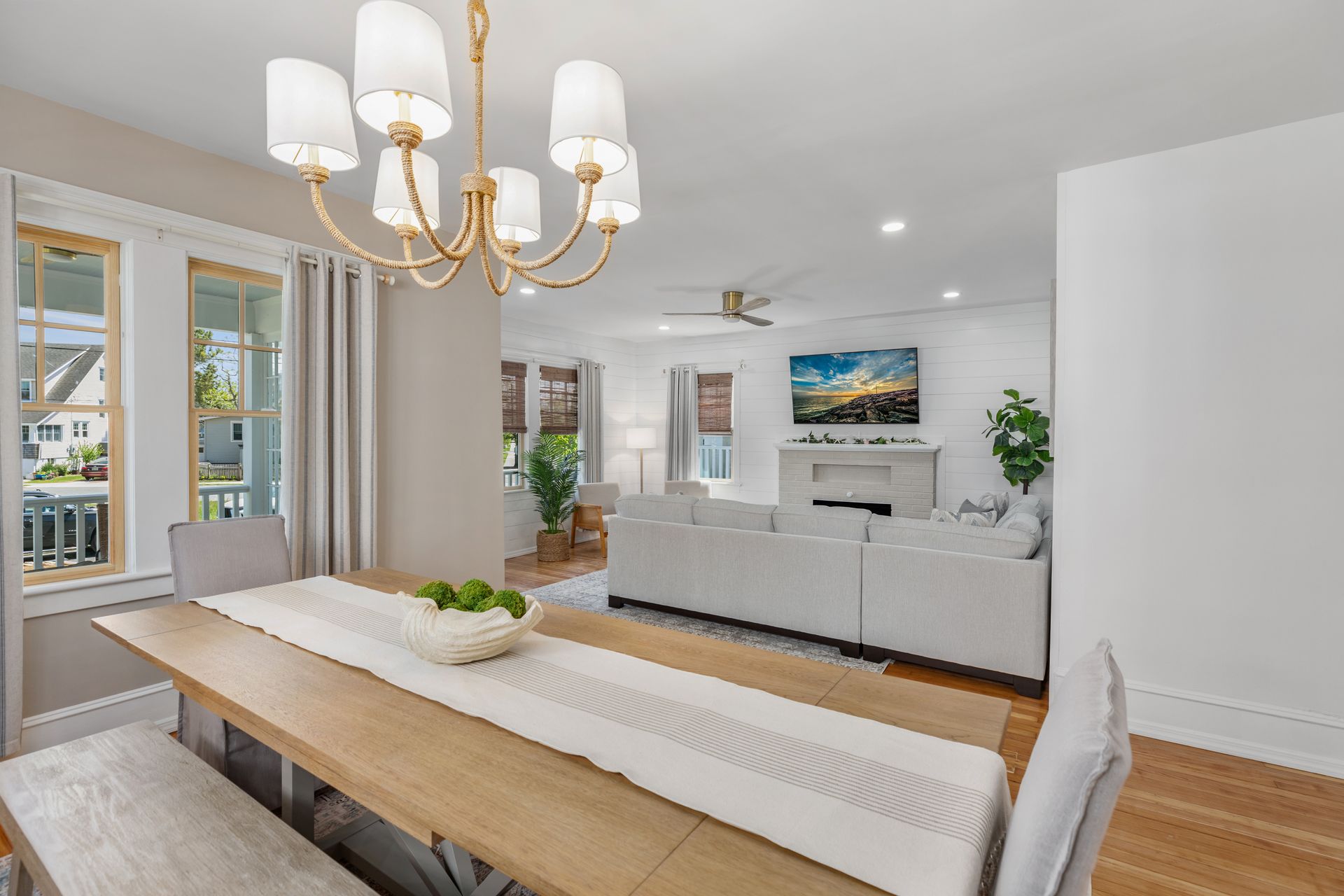 A dining room table with a chandelier hanging from the ceiling.
