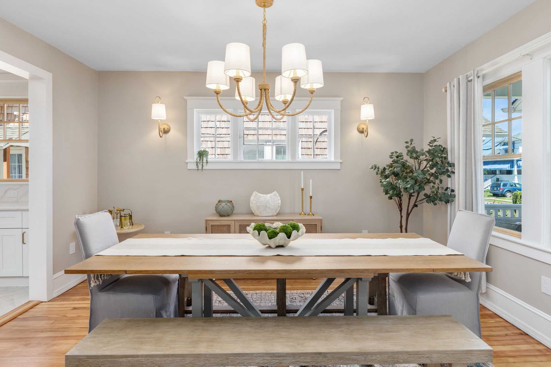 A dining room with a wooden table and chairs and a chandelier.