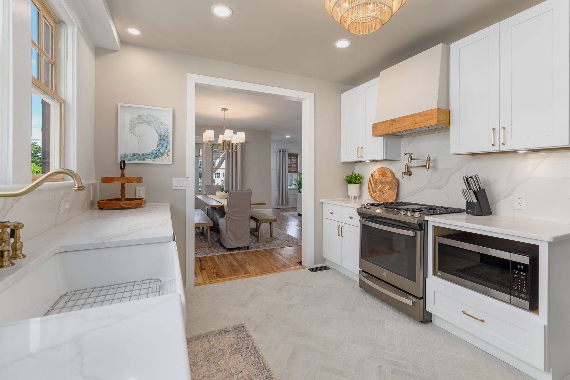 A kitchen with white cabinets , stainless steel appliances , a sink , and a stove.