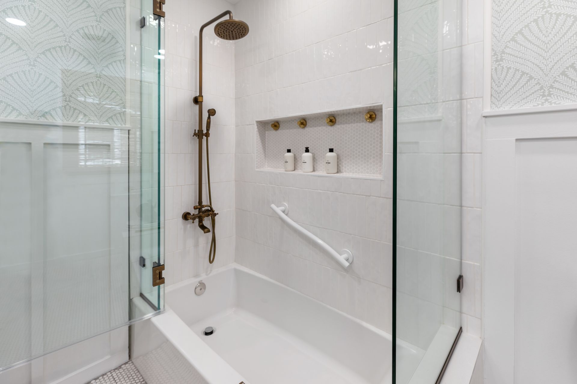 A bathroom with a bathtub and a shower with a glass door.