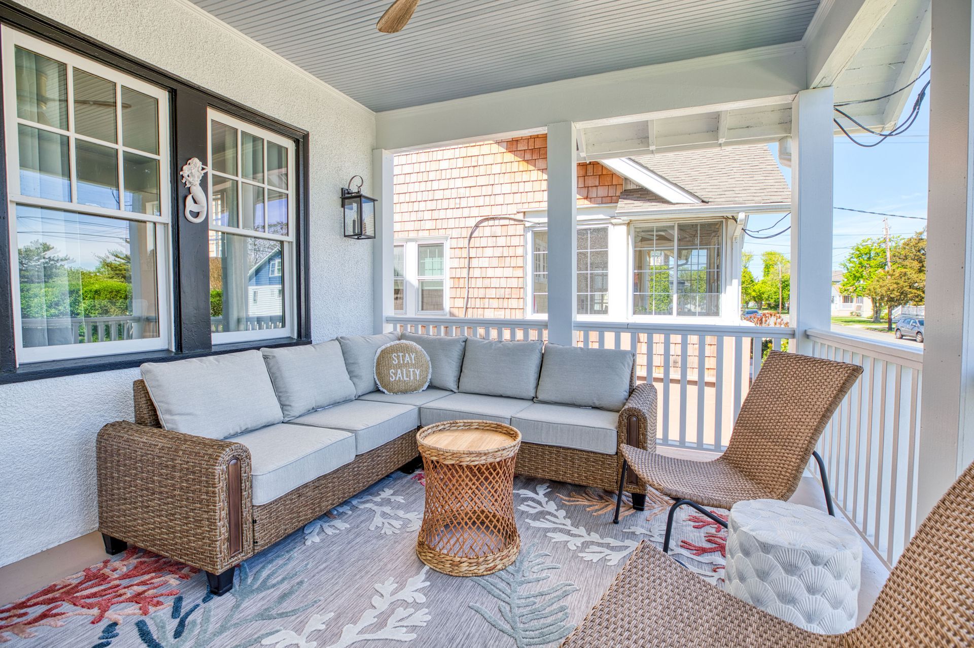 A porch with a couch , chairs , and a table.