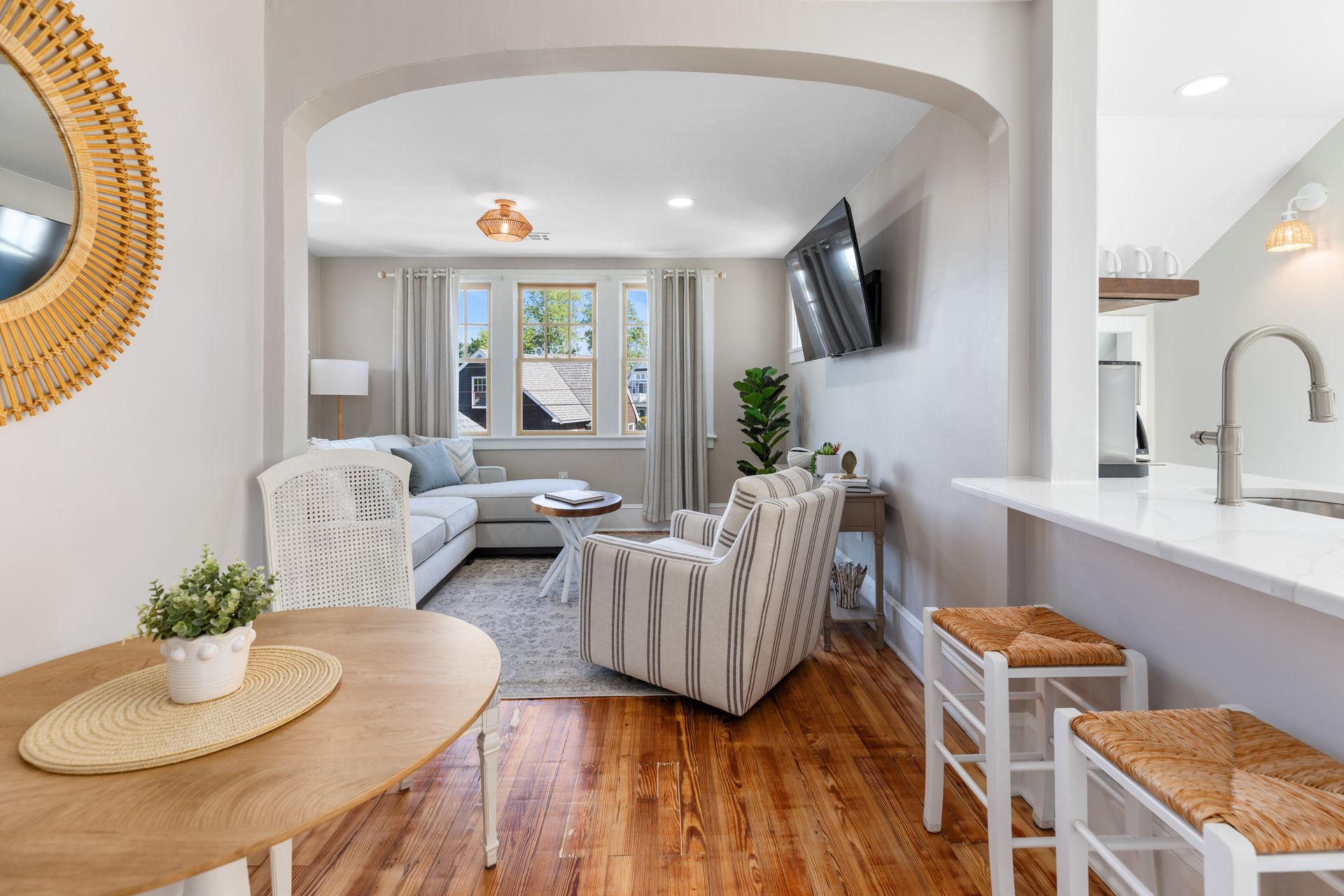 A living room with a table , chairs , and a flat screen tv.