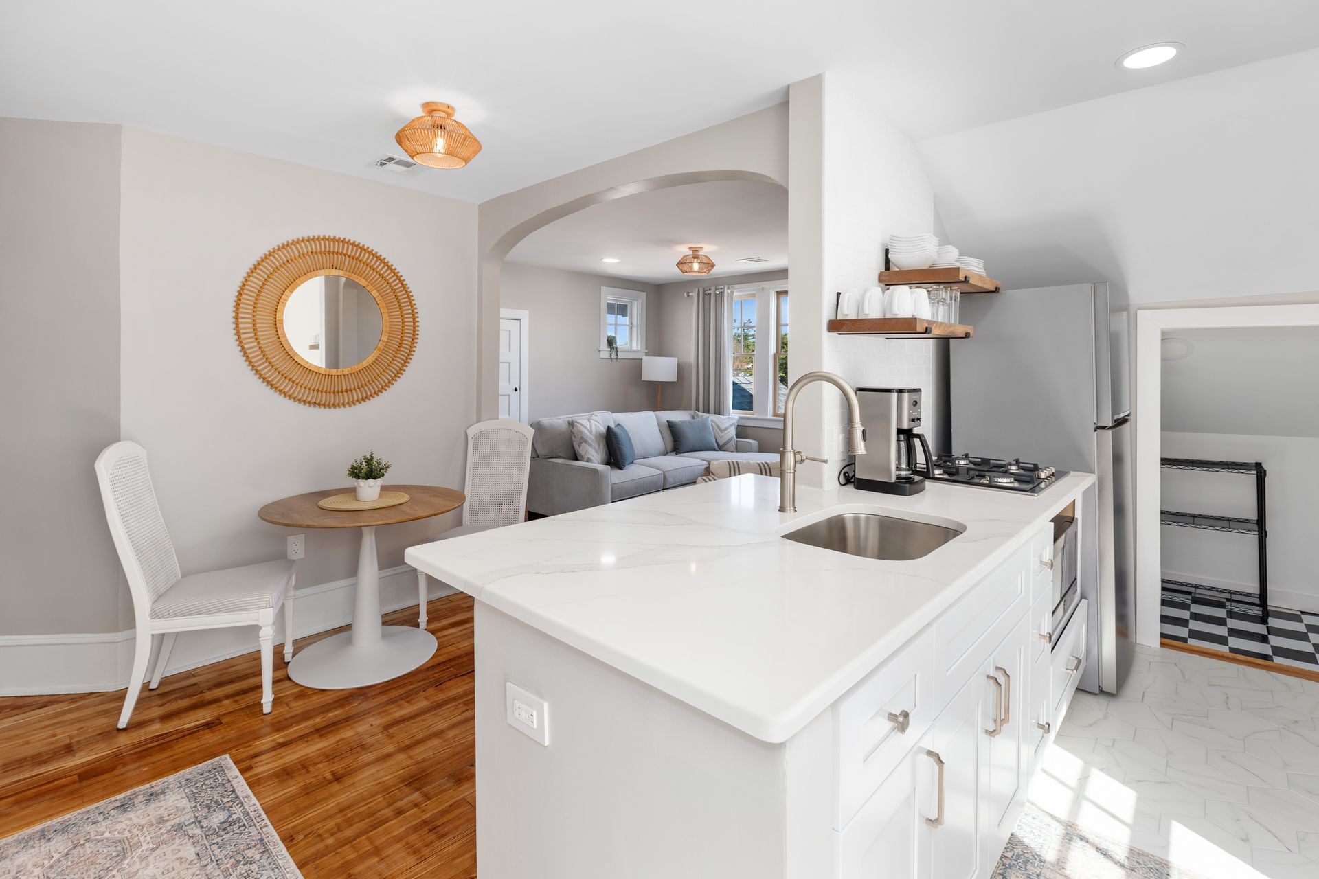 A kitchen with a sink , stove , refrigerator , table and chairs.