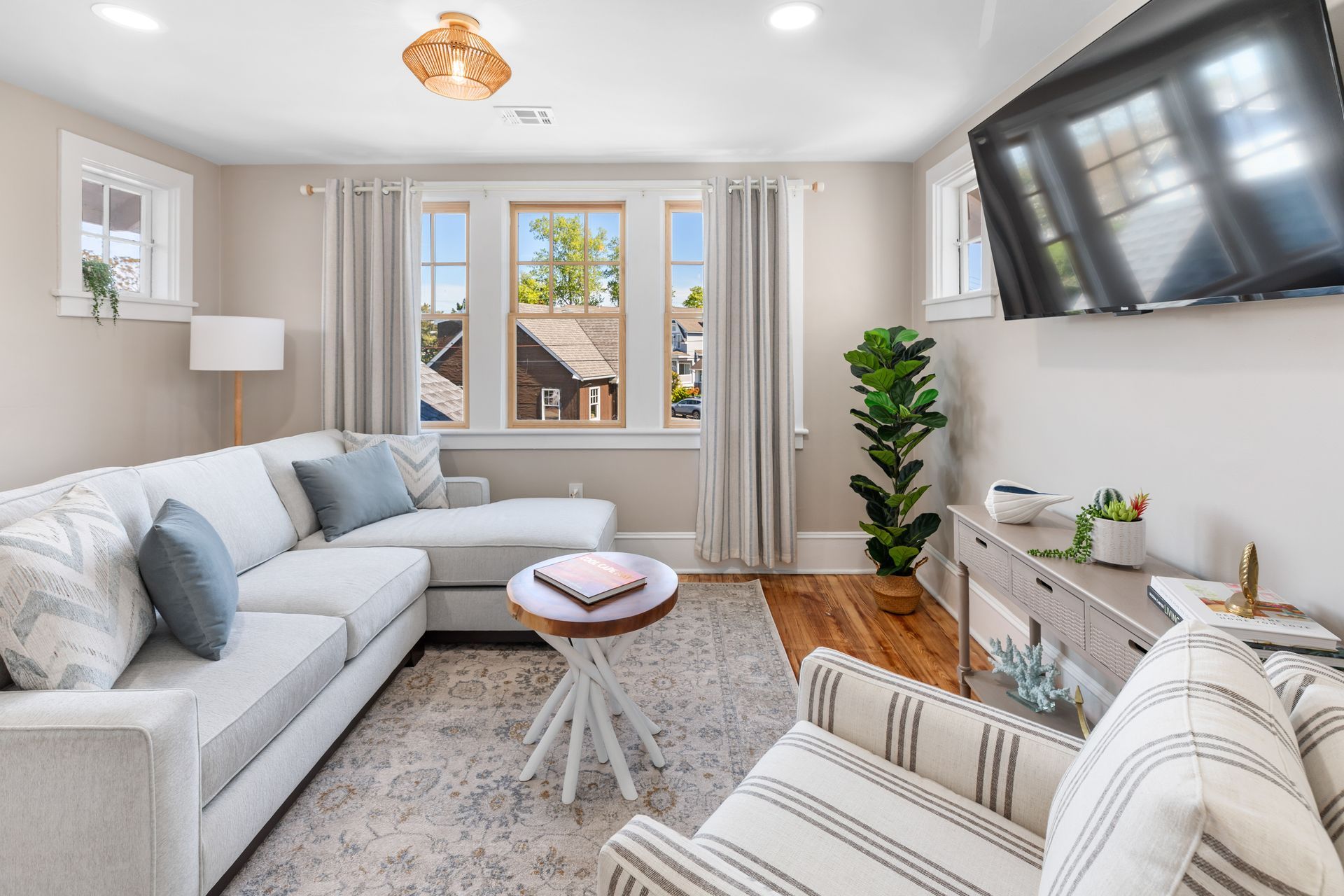 A living room with a couch , chair , table and television.