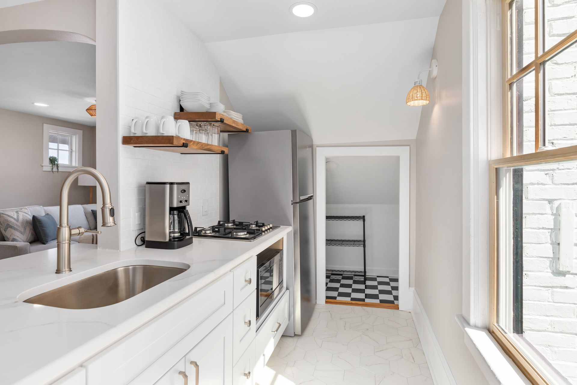 A kitchen with a sink , stove , refrigerator and microwave.