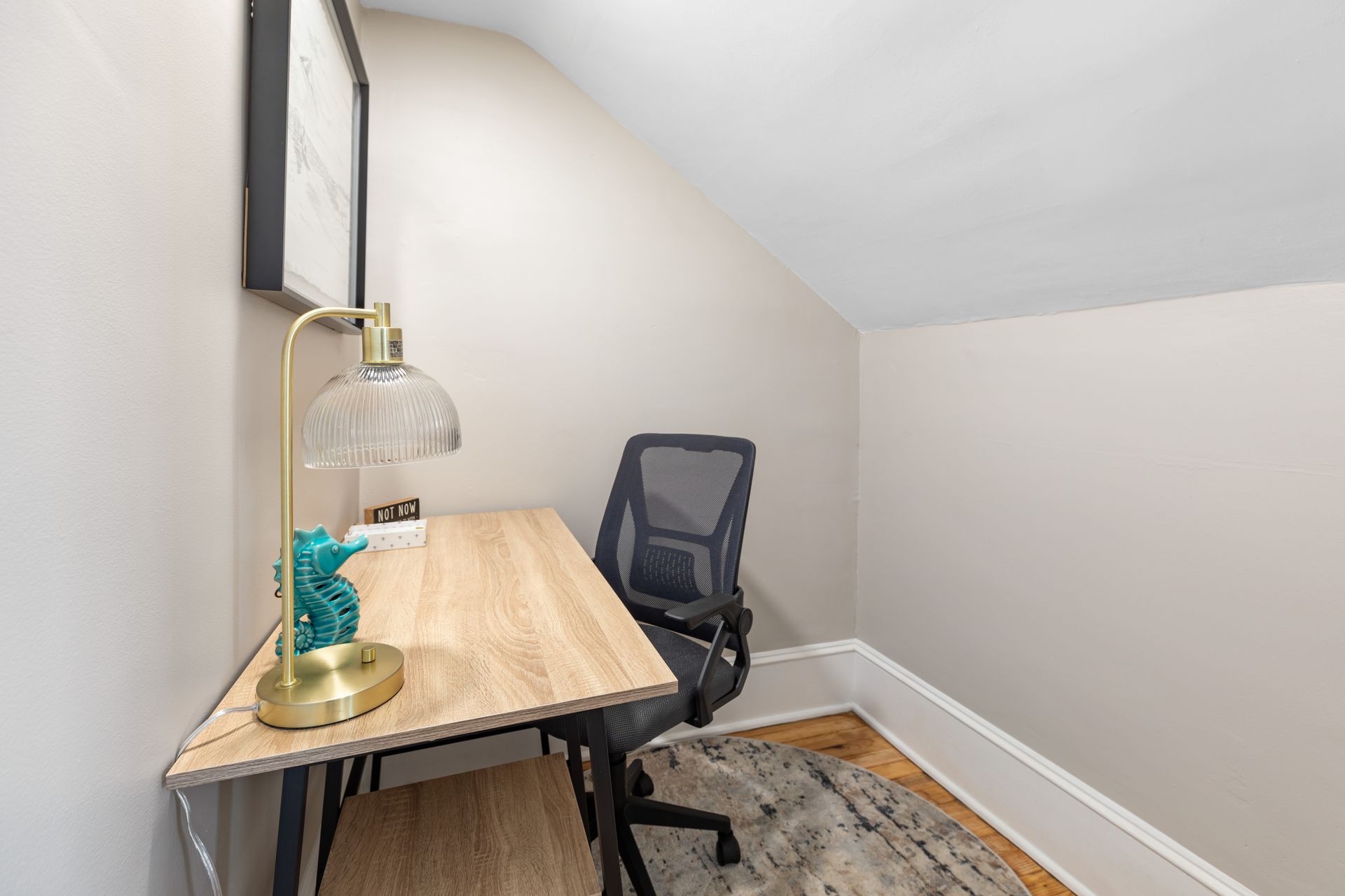 There is a desk and chair in the corner of the room.
