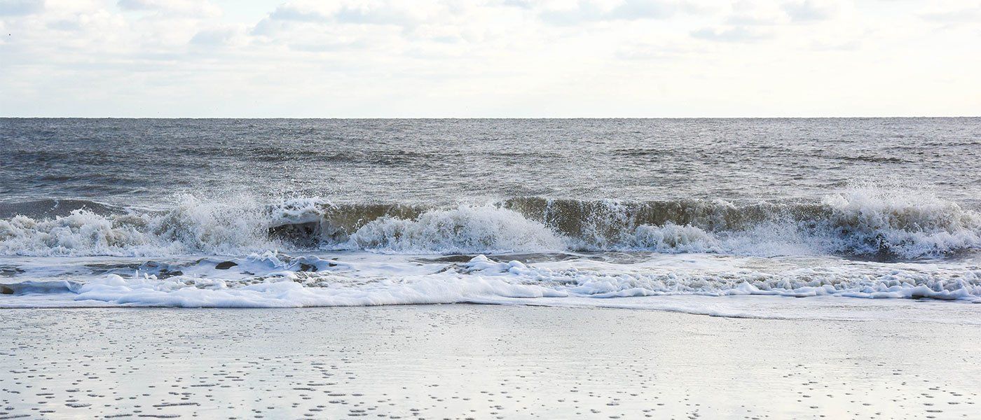 A blurred image of waves crashing on a beach.