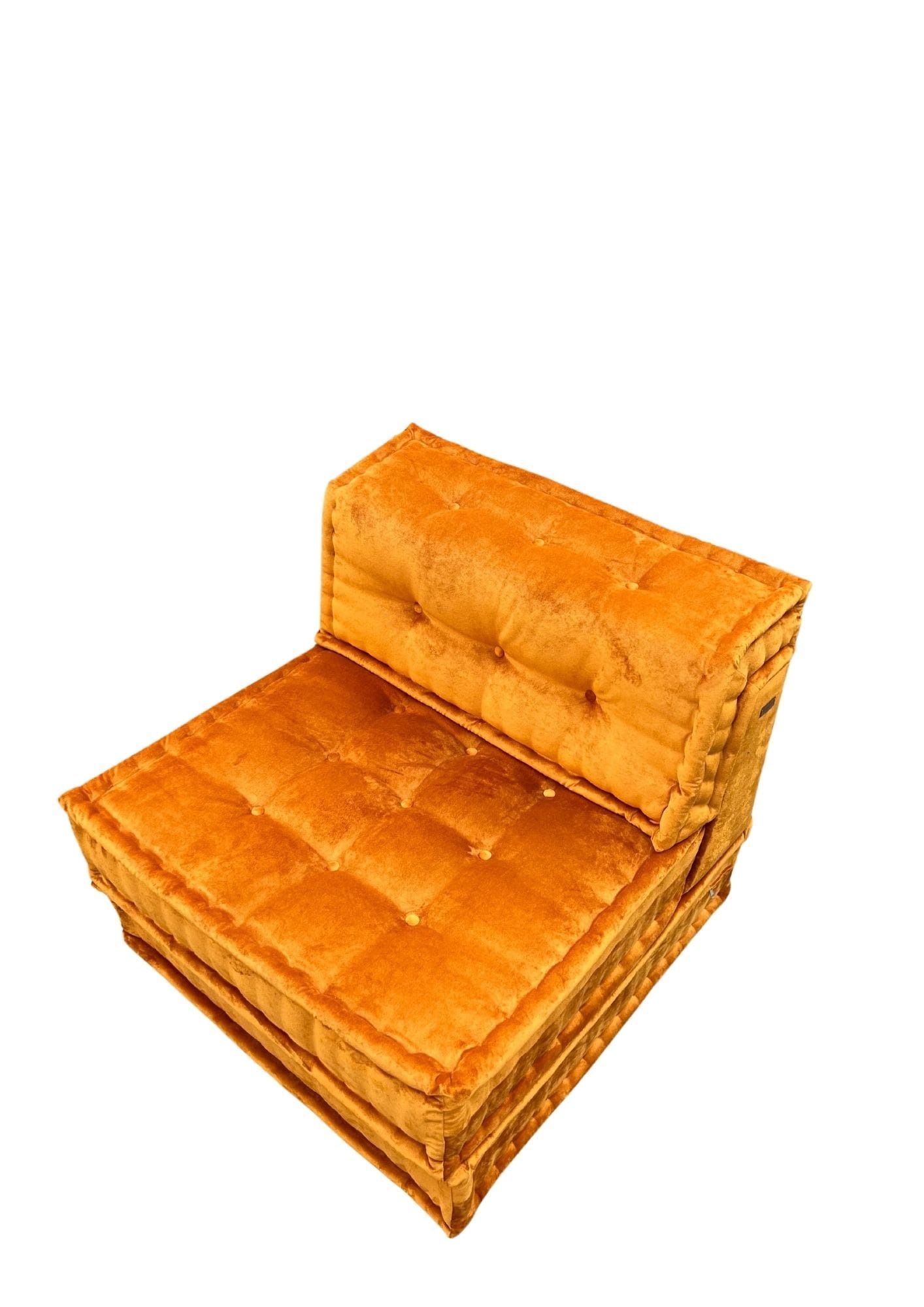 Poltrona capitonné arancione su sfondo bianco.