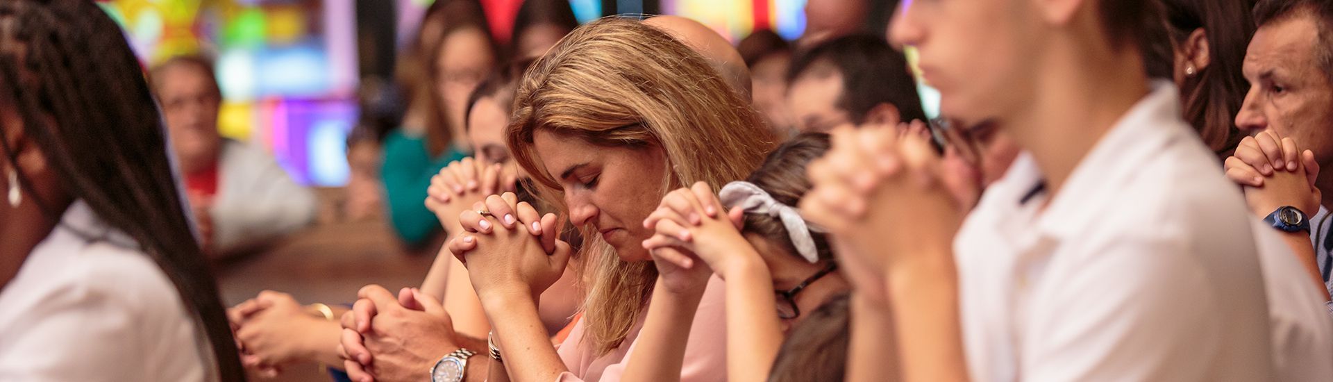 A group of people are praying together in a church.