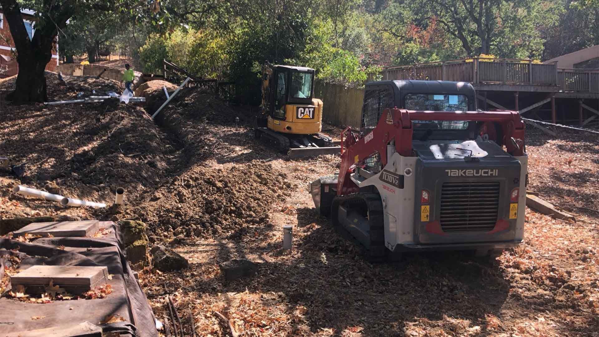 A bulldozer is parked in a dirt field next to a smaller bulldozer.