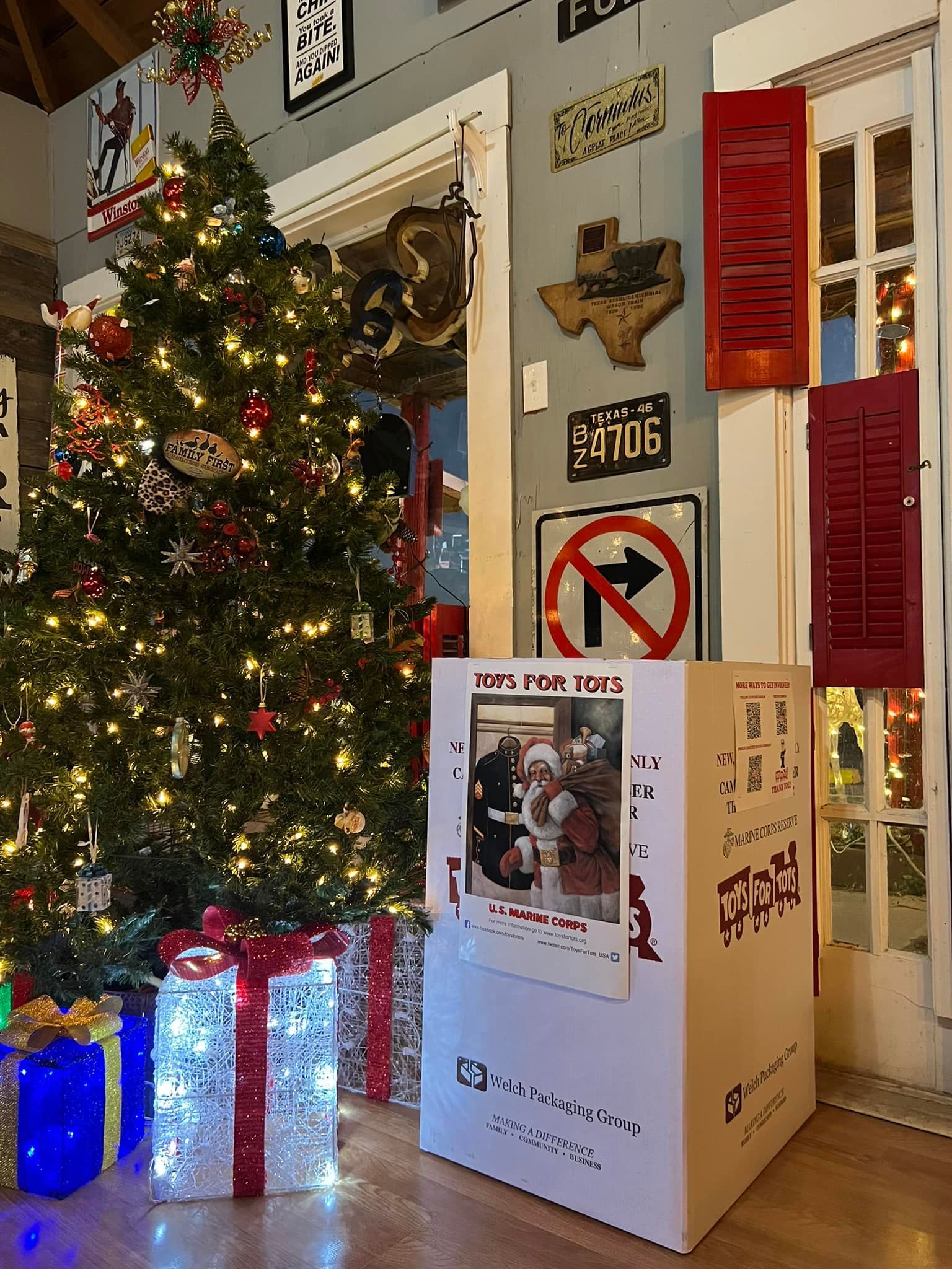Christmas tree with glowing gifts in a cozy room beside a large white pet crate or box