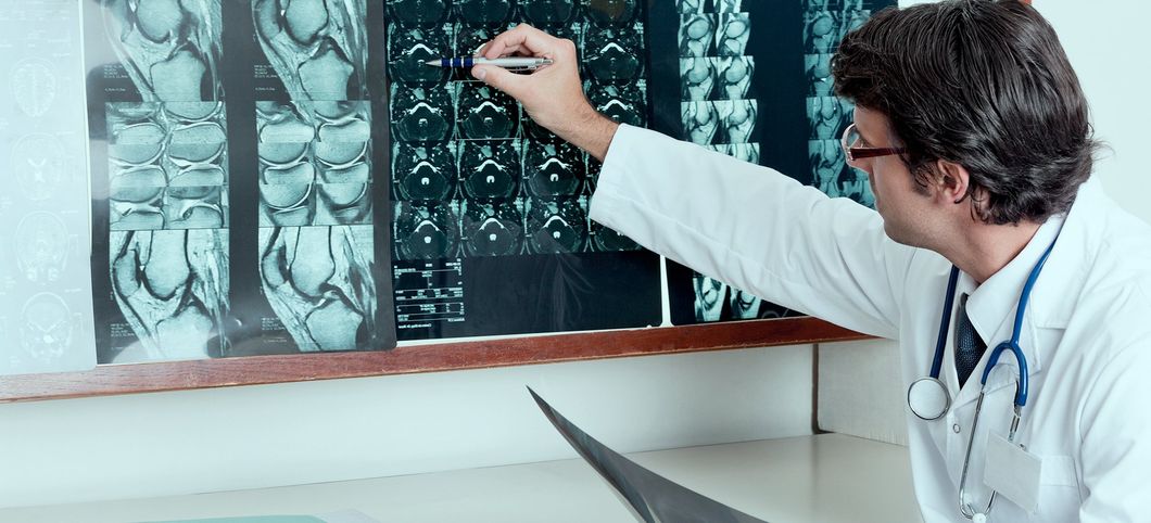 Un medico esamina delle radiografie su un tavolo luminoso in uno studio medico.