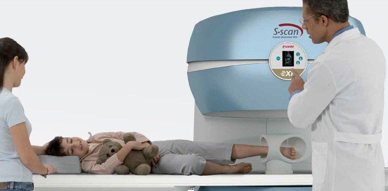 Scansione di diagnostica per immagini medica con paziente sul lettino e tecnico addetto allo scanner.