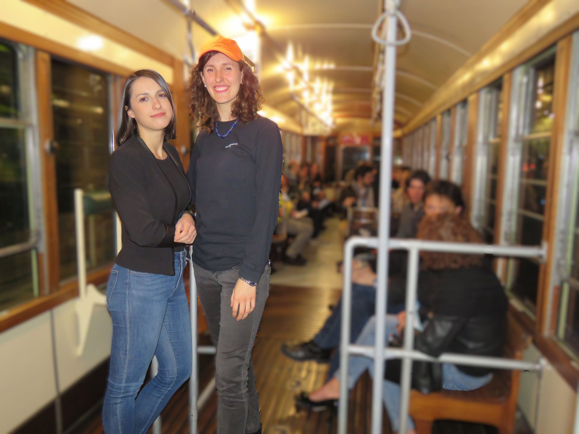 Due ragazze sono in piedi una accanto all'altra sul tram storico