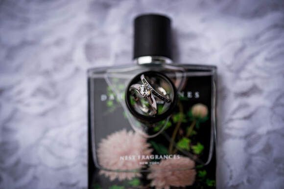 A bottle of perfume with a wedding ring in it.