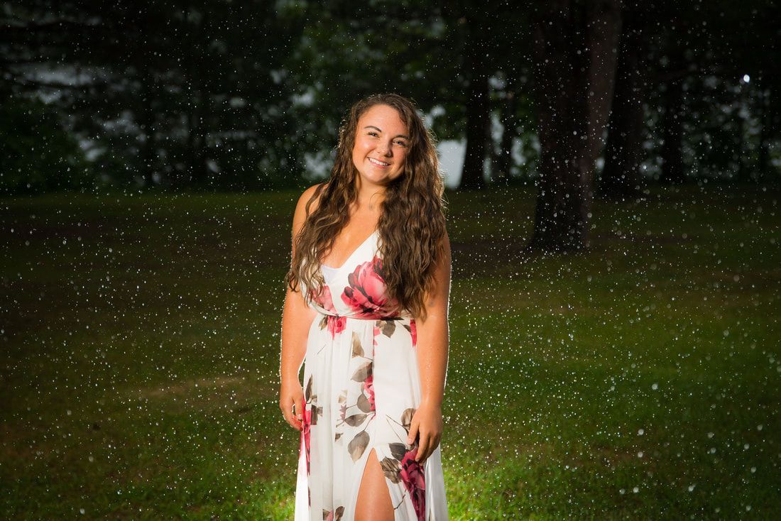 A woman in a white dress is standing in the rain.