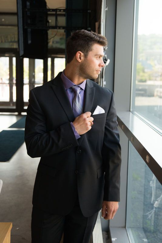 A man in a suit and tie is looking out a window