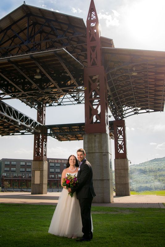 A bride and groom are posing for a picture in front of a large building.