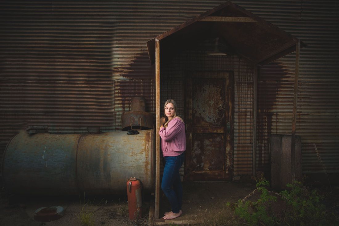 A woman is standing in a doorway of an old building.