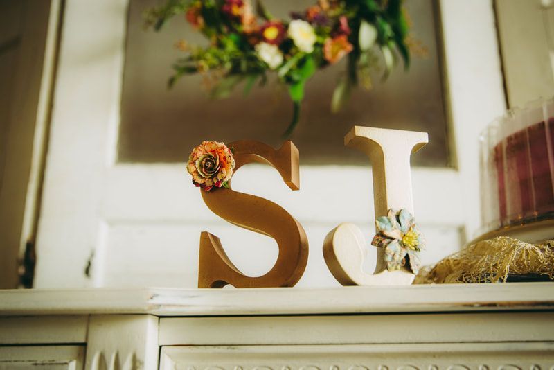 A wooden letter s is sitting on top of a white dresser.