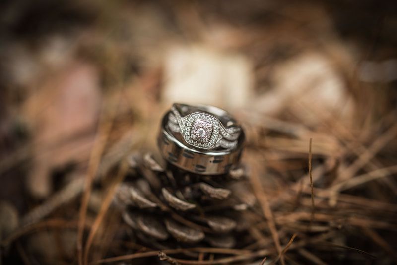 A close up of a wedding ring on top of a pine cone.