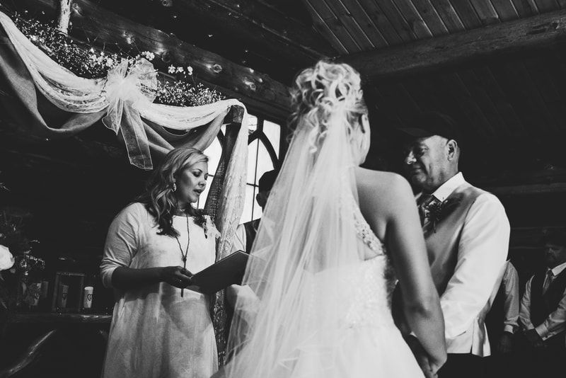 A bride and groom are getting married in a black and white photo.