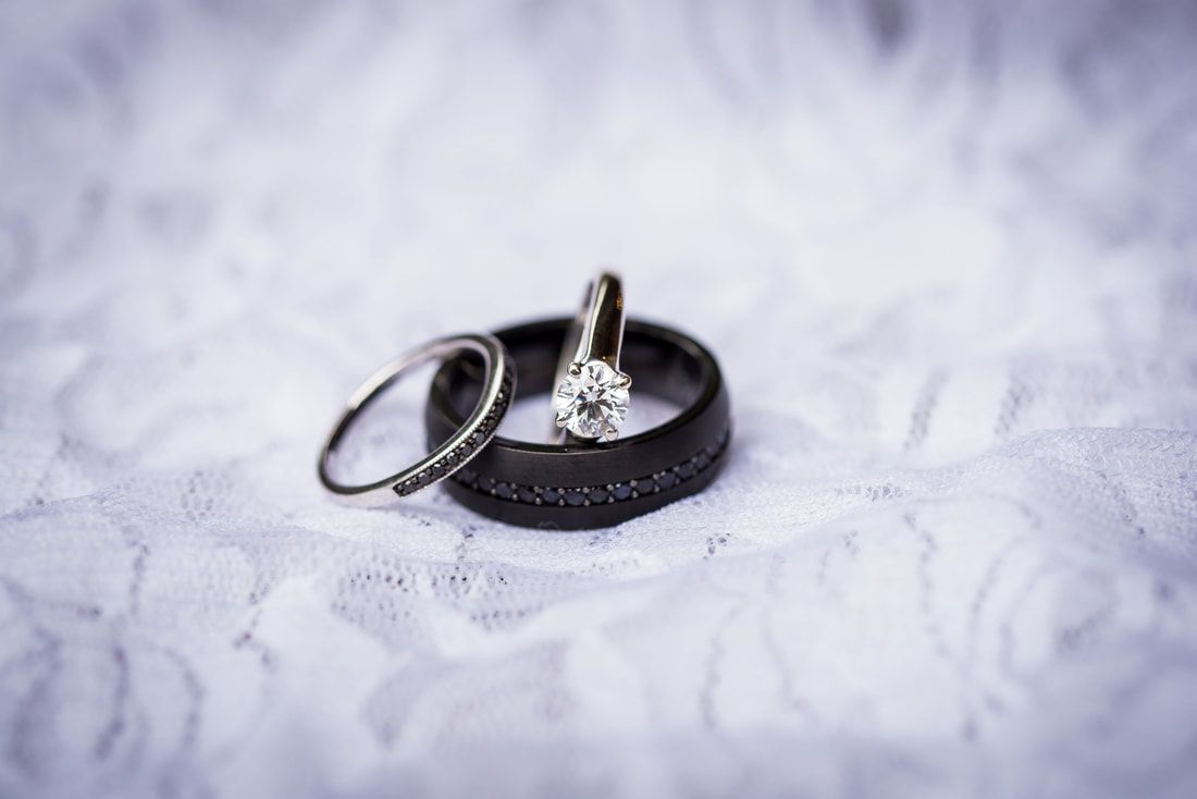 A close up of a bride and groom 's wedding rings on a white cloth.