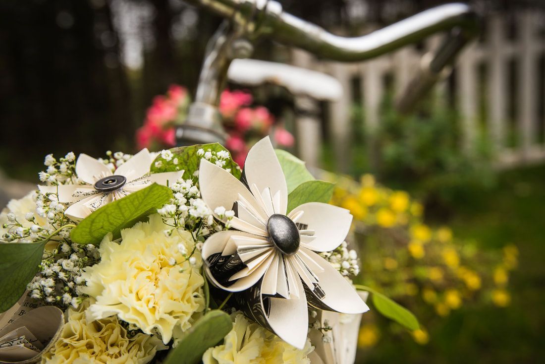 A close up of a bouquet of flowers on a bicycle.