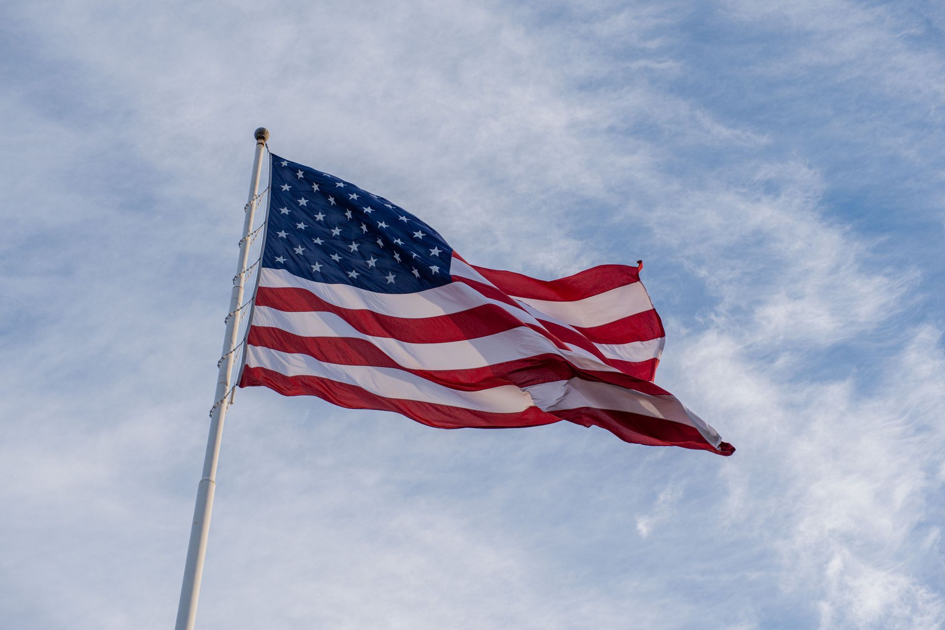 American flag waving against a cloudy sky