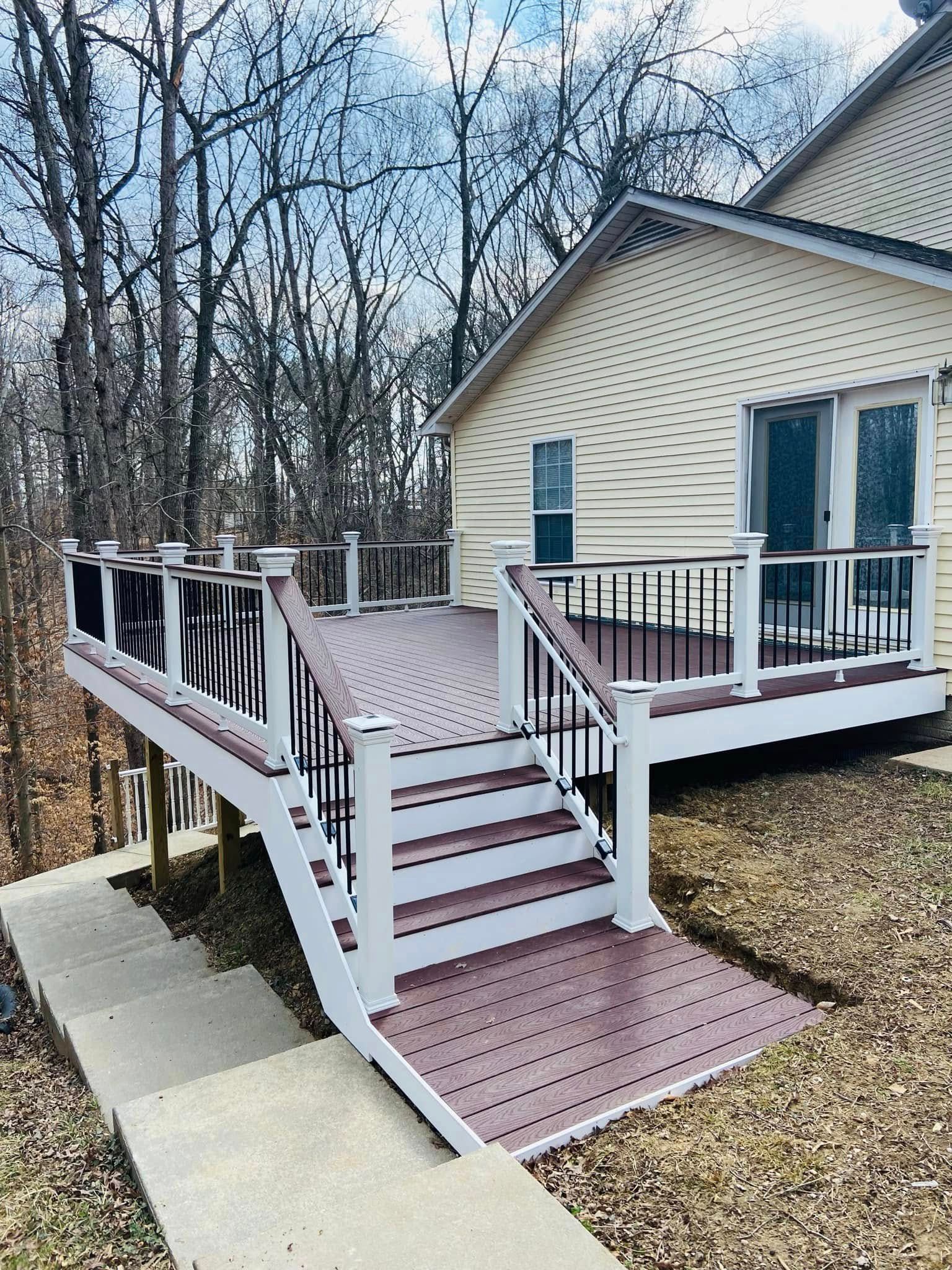 Accessible deck ramp and stairs beside a house with white railings and brown steps