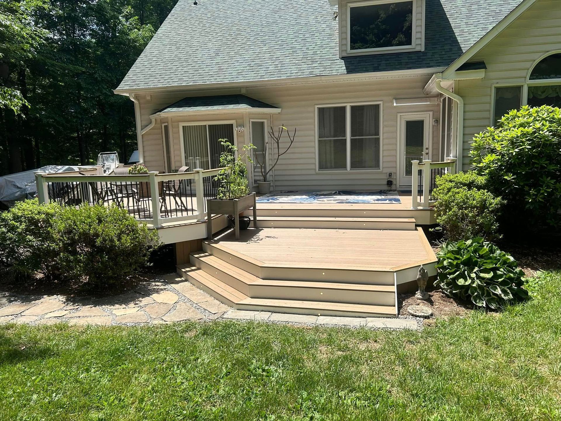 A house with a wooden deck and stairs in front of it.